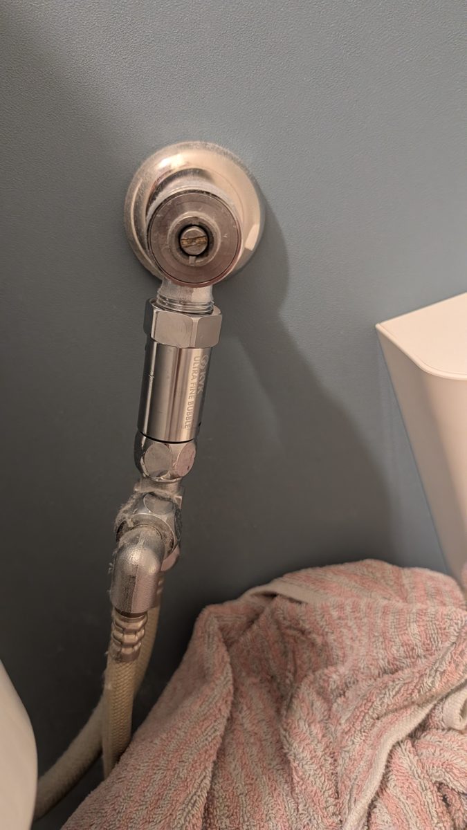 付けた後のトイレの給水。止水栓と分岐金具の間に、銀色の円筒形のジョイントが入っている
